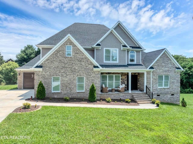 craftsman inspired home with a porch, concrete driveway, a front lawn, roof with shingles, and a garage