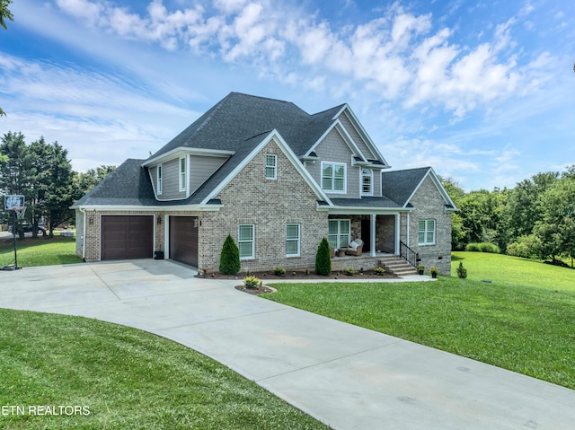 craftsman-style home featuring driveway, covered porch, a shingled roof, and a front lawn