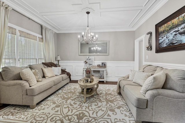 living room featuring a chandelier, wood finished floors, crown molding, wainscoting, and a decorative wall