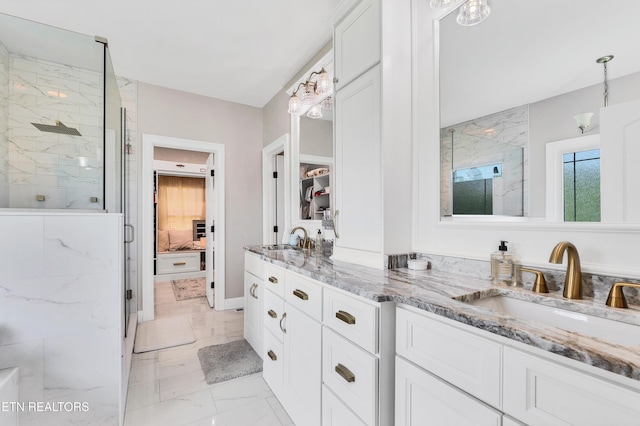 bathroom featuring marble finish flooring, a marble finish shower, and double vanity