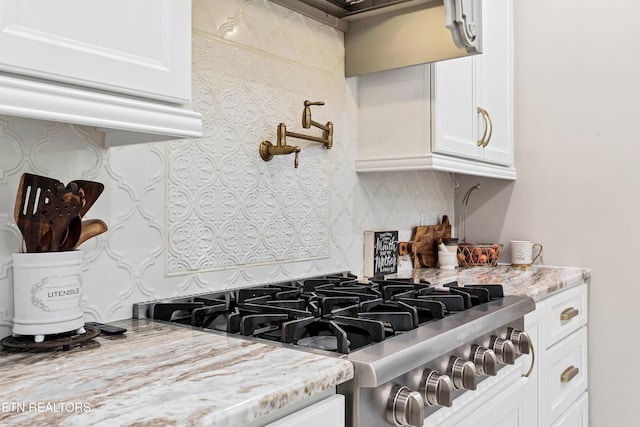 kitchen featuring backsplash, white cabinets, and stainless steel gas stovetop