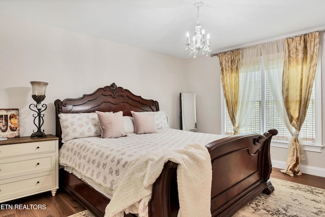 bedroom with a chandelier and dark wood-style flooring