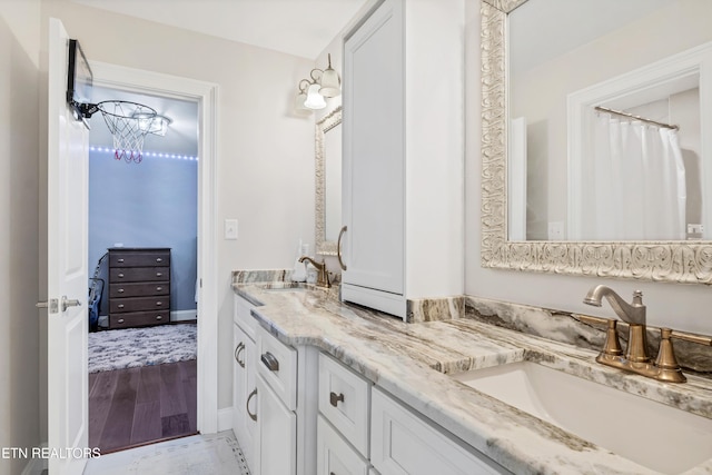 full bathroom featuring double vanity and wood finished floors