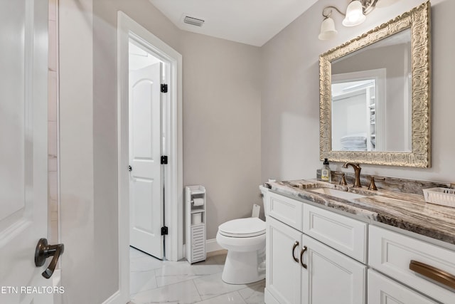 bathroom with marble look tile flooring and vanity