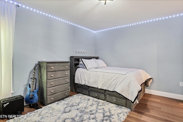 bedroom featuring baseboards and wood finished floors