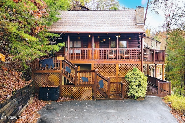 716 Golden Eagle Way, Pigeon Forge, TN 37863 - rustic home with log siding, stairs, a chimney, covered porch, and a shingled roof