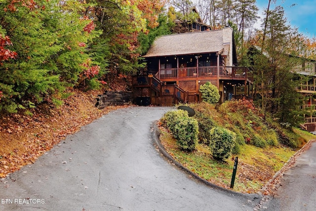 716 Golden Eagle Way, Pigeon Forge, TN 37863 - rustic home with driveway, covered porch, stairway, a chimney, and a shingled roof
