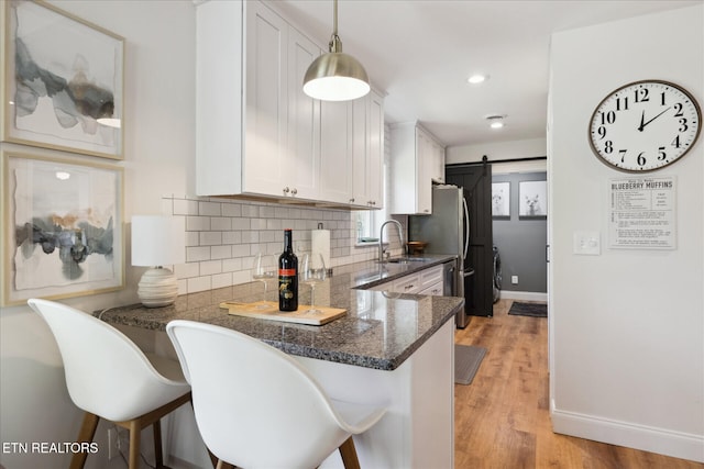 335 Sugar Mountain Way, Pigeon Forge, TN 37863 - kitchen featuring a breakfast bar, white cabinets, backsplash, a peninsula, and recessed lighting