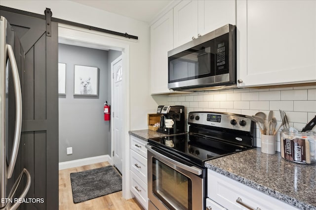 335 Sugar Mountain Way, Pigeon Forge, TN 37863 - kitchen with appliances with stainless steel finishes, backsplash, light wood-style flooring, and white cabinets