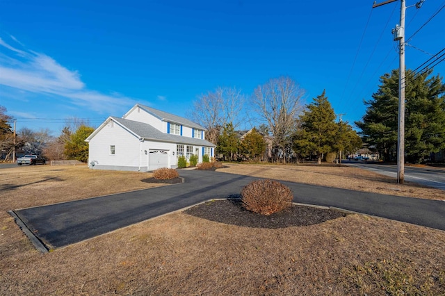 view of side of home with driveway and a lawn