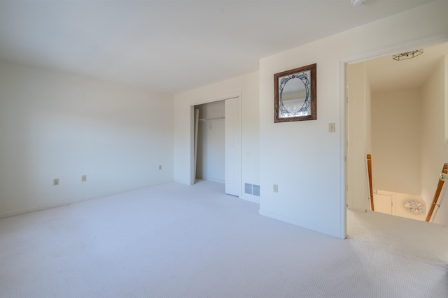 unfurnished bedroom featuring a closet, visible vents, and carpet flooring