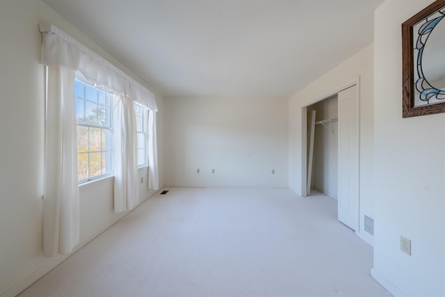 carpeted bedroom featuring visible vents and a closet