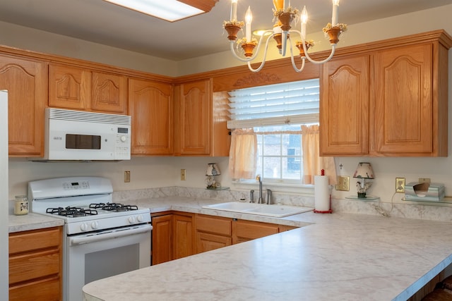 kitchen with light countertops, an inviting chandelier, a sink, white appliances, and a peninsula