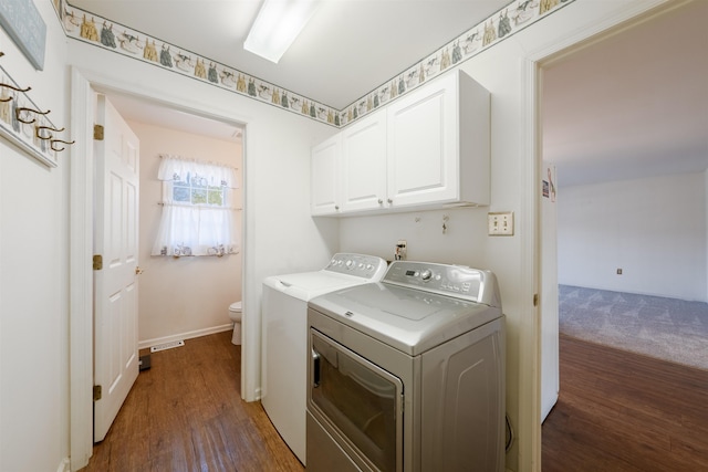 laundry area featuring baseboards, cabinet space, dark wood finished floors, and washing machine and clothes dryer