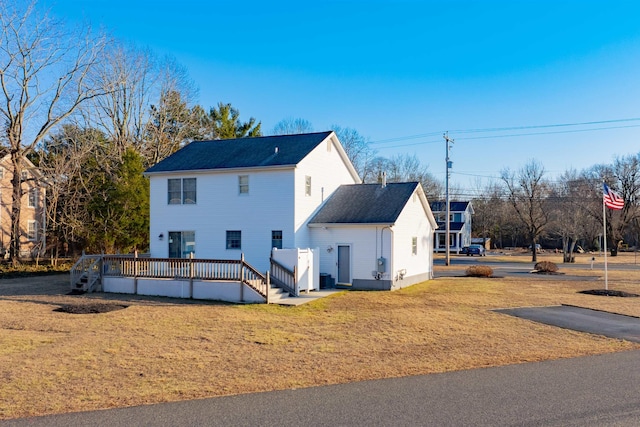 exterior space with a front lawn and a wooden deck