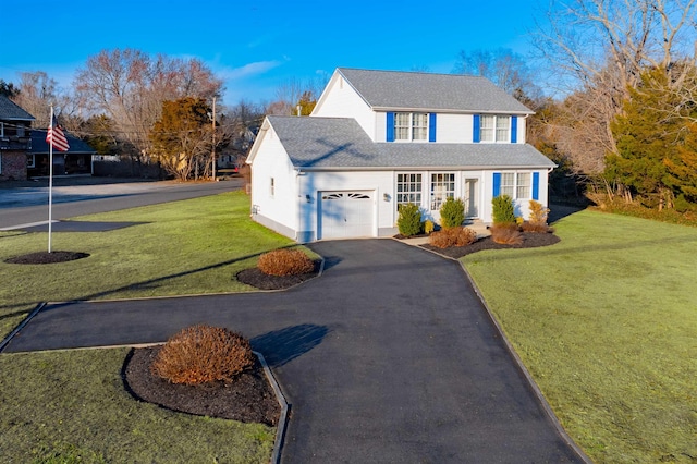 traditional home featuring a garage, a front yard, roof with shingles, and driveway