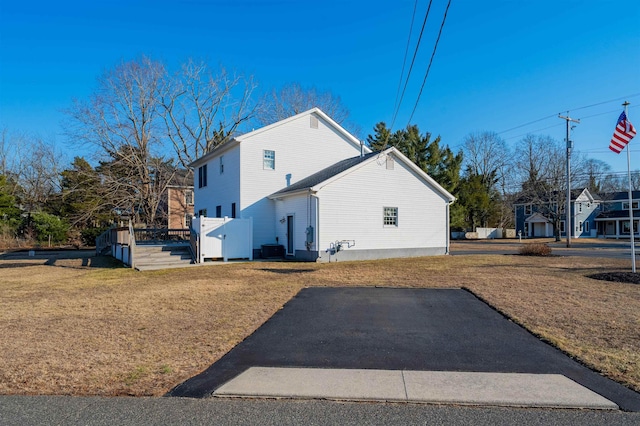 view of property exterior featuring central AC and a lawn