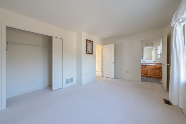 unfurnished bedroom featuring a sink, a closet, visible vents, and carpet flooring