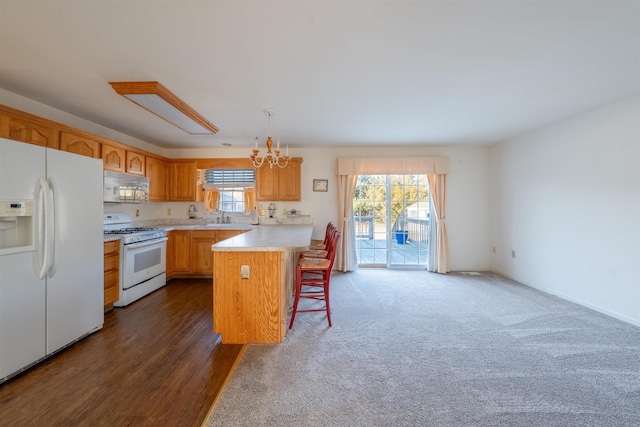 kitchen featuring light countertops, an inviting chandelier, white appliances, a peninsula, and a kitchen breakfast bar