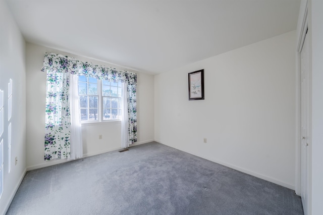 carpeted spare room featuring visible vents