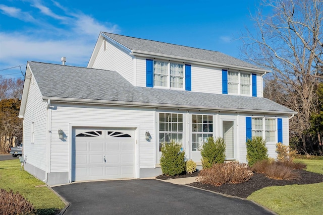 traditional-style home featuring a shingled roof, driveway, and an attached garage