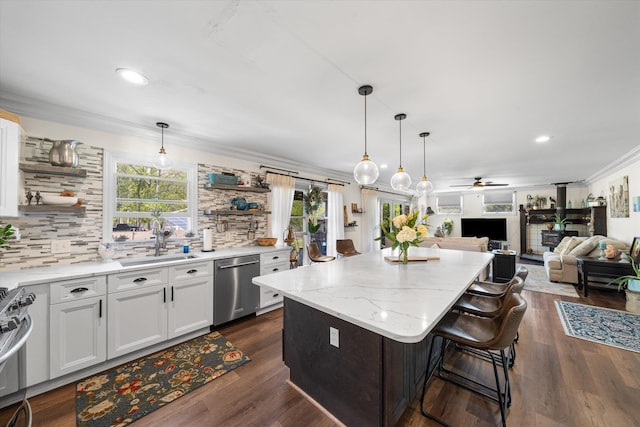 kitchen featuring appliances with stainless steel finishes, a center island, white cabinetry, and sink