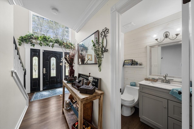 foyer entrance with dark hardwood / wood-style floors, ornamental molding, and sink