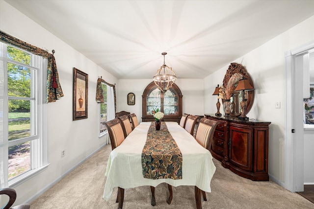 carpeted dining space with a chandelier