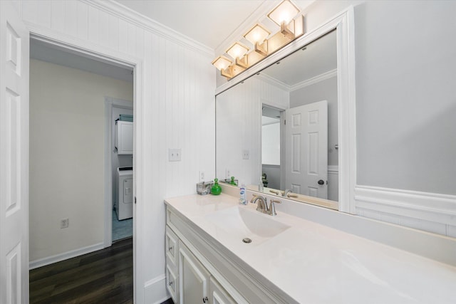 bathroom with wood-type flooring, vanity, washer / clothes dryer, and ornamental molding