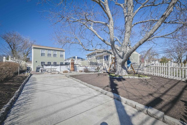 exterior space featuring a fenced front yard, a residential view, and aphalt driveway