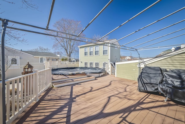 deck with a jacuzzi and fence