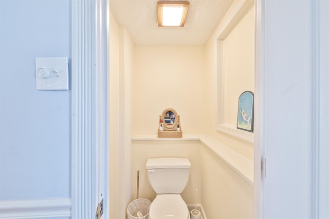 bathroom featuring a textured ceiling and toilet