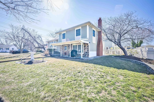 view of front of property with stone siding, a chimney, a front yard, and fence