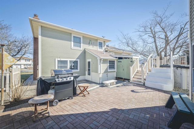 rear view of house featuring fence, a chimney, and a patio area