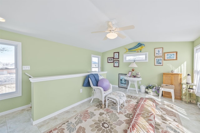 sitting room with tile patterned flooring, vaulted ceiling, a ceiling fan, and baseboards