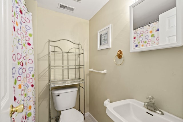 bathroom with baseboards, visible vents, a sink, and toilet