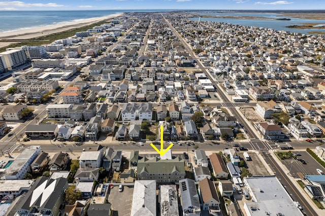 drone / aerial view with a beach view, a water view, and a residential view