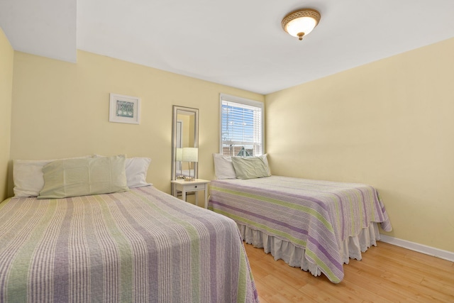 bedroom featuring light wood-style floors and baseboards