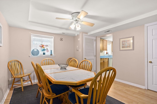 dining room featuring visible vents, ceiling fan, light wood-style flooring, and baseboards