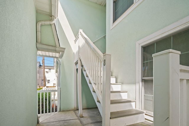 stairs with a textured wall and a towering ceiling