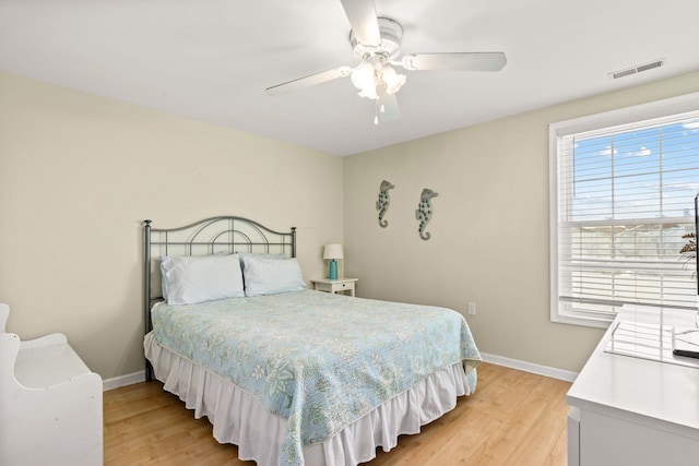 bedroom featuring a ceiling fan, light wood-type flooring, visible vents, and baseboards