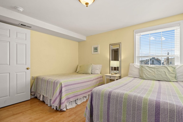 bedroom featuring visible vents and wood finished floors