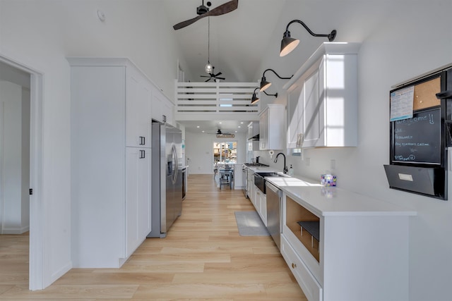 kitchen featuring white cabinets, a ceiling fan, high vaulted ceiling, and appliances with stainless steel finishes