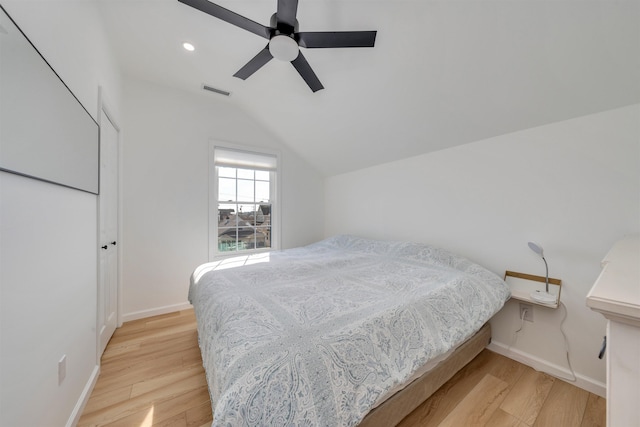 bedroom featuring light wood finished floors, baseboards, visible vents, lofted ceiling, and ceiling fan