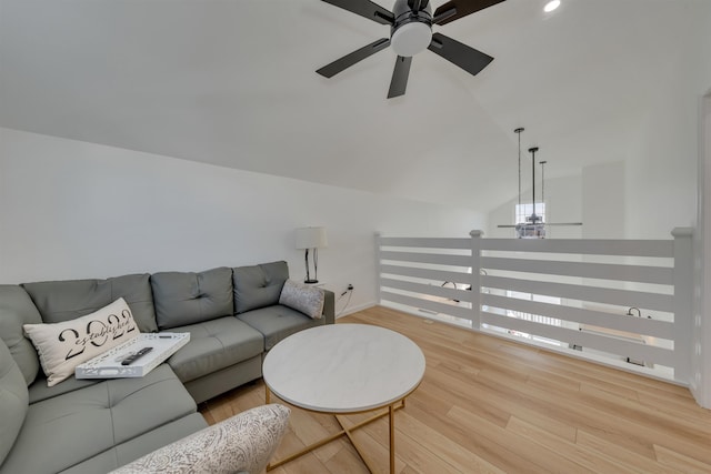 living room featuring baseboards, a ceiling fan, wood finished floors, and vaulted ceiling