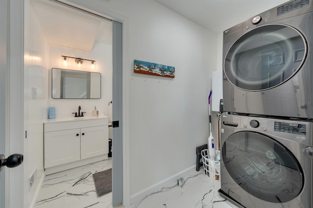 laundry room with a sink, marble finish floor, baseboards, stacked washer and clothes dryer, and laundry area