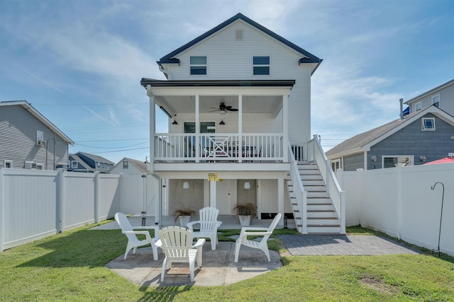back of house with stairs, a fenced backyard, ceiling fan, a patio area, and a lawn