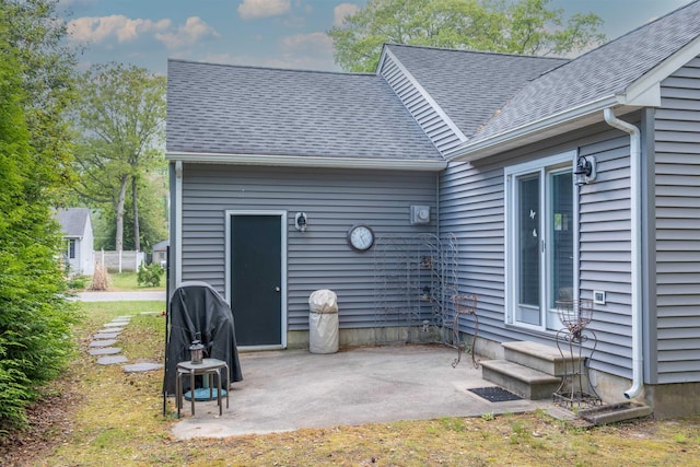 back of house featuring roof with shingles, entry steps, and a patio area