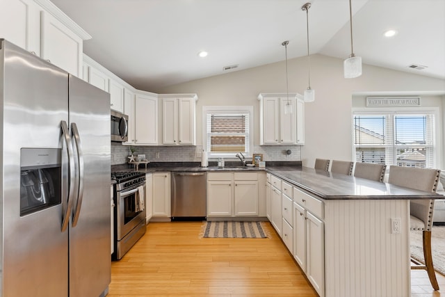 320 E 18th Ave Unit 200, North Wildwood, NJ 08260 - kitchen with appliances with stainless steel finishes, a peninsula, plenty of natural light, vaulted ceiling, and a breakfast bar