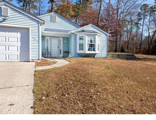 ranch-style home with a garage, driveway, and a front lawn